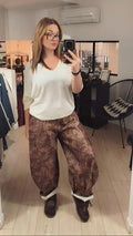 Pantalon barrel imprimé militaire marron porté avec un pull fin écrue. 