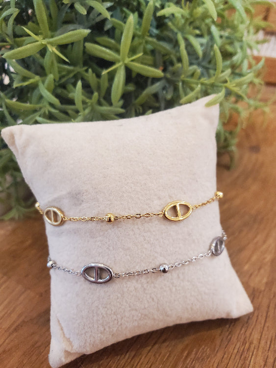 Bracelet KFE chaine fine colorie argent et or. photo sur un coussin .