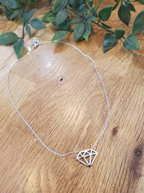 Collier dont le pendentif en métal reprend la forme géométrique d'un diamant. Colorie Argent