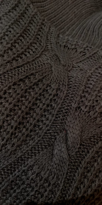 Pull col roulé en maille torsadé . photo détail de la torsade colorie noir.