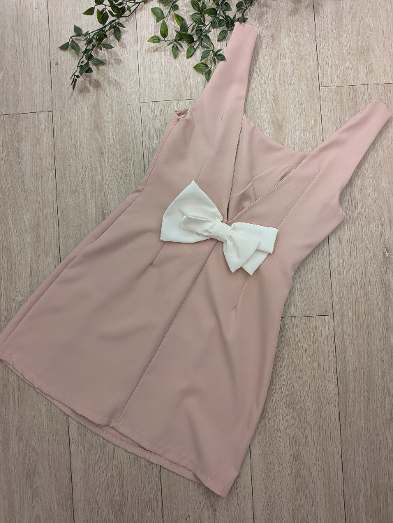 Robe rose pale décolleté en V dans le dos sublimé par un noeud blanc. 