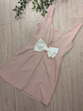 Robe rose pale décolleté en V dans le dos sublimé par un noeud blanc. 