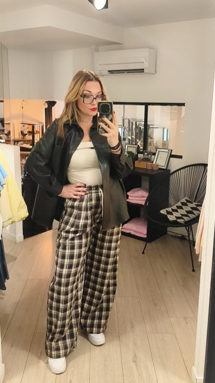 Pantalon a carreaux porté avec un bandeau fendu beige et une chemise en simili cuir