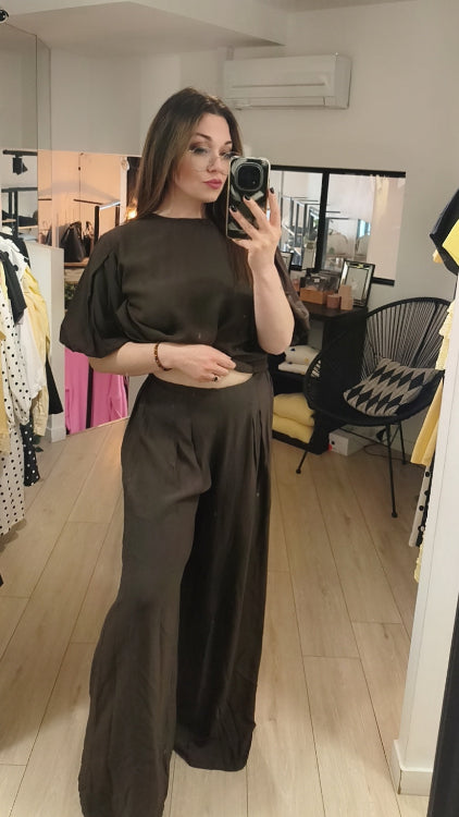 Pantalon large effet lin porté avec un top dans le même tissus . Colorie marron . 