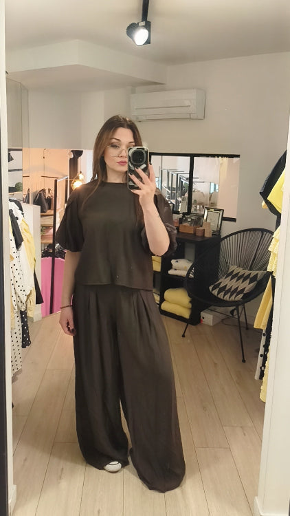 Pantalon large effet lin porté avec un top dans le même tissus . Colorie marron . 