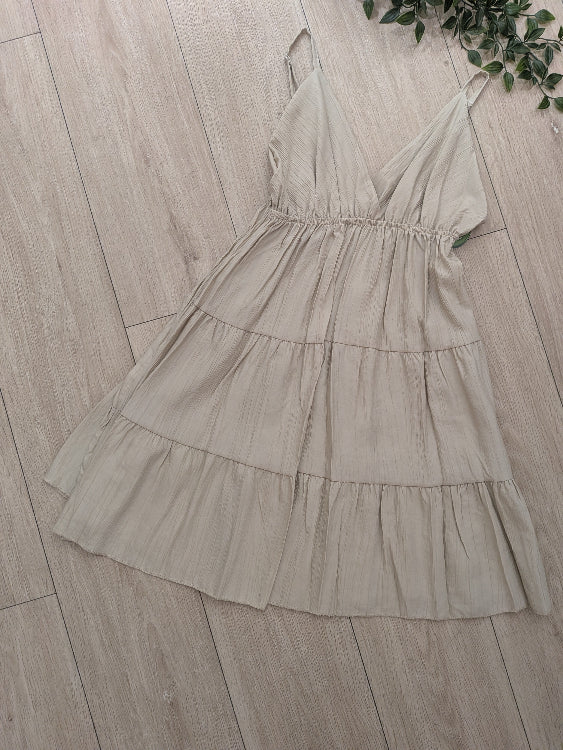 Robe courte fine bretelle a volant. photo a plat colorie beige