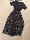 Robe longue bi-matière a pois blanc sur fond noir. Photo a plat. 