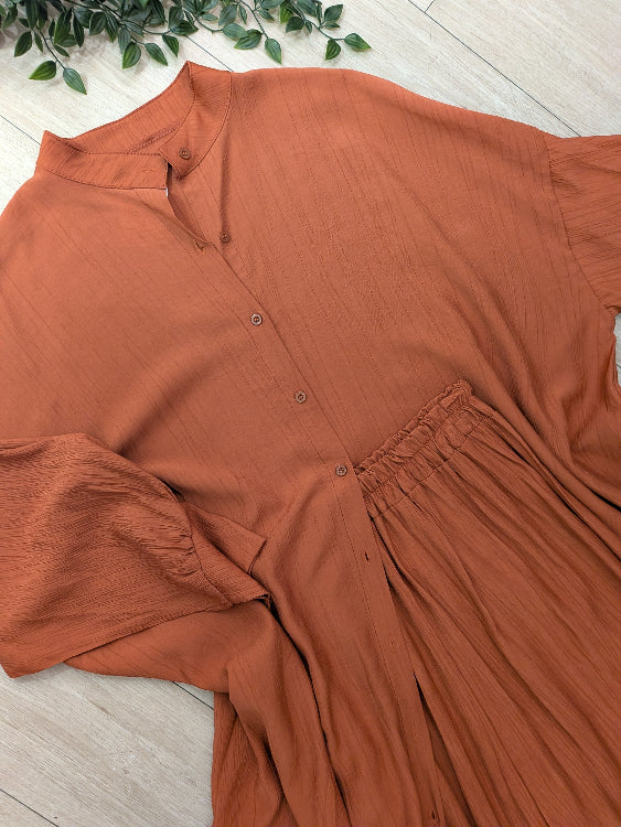Ensemble composé d'une chemise longue et d'un pantalon. photo a plat colorie brique 
