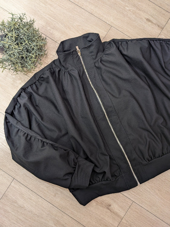 Blouson manches froncées noir . photo a plat. 