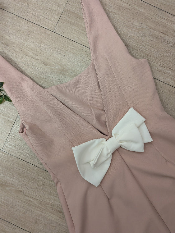 Robe rose pale décolleté en V dans le dos sublimé par un noeud blanc. 