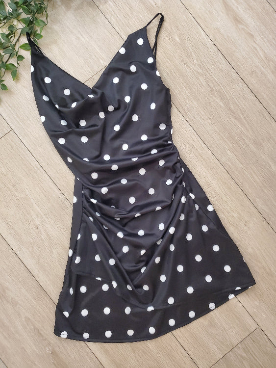 Robe courte drapé en tissus noir a pois blanc. Photo a plat. 