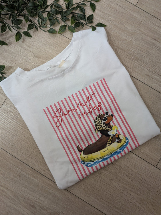 T-shirt imprimé chien avec lunettes de soleil, foulard léopard sur une bouée savourant un cocktail. Photo a plié. 