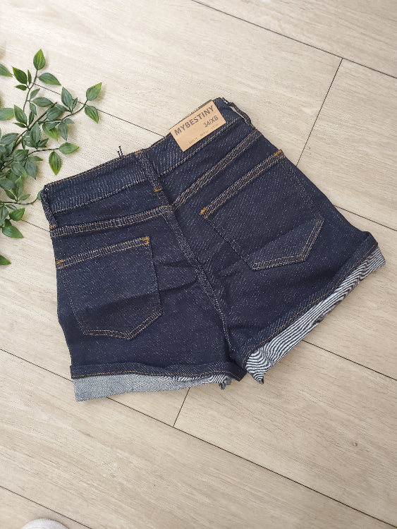 Short en jean brut foncé avec revers. photo a plat dos. 