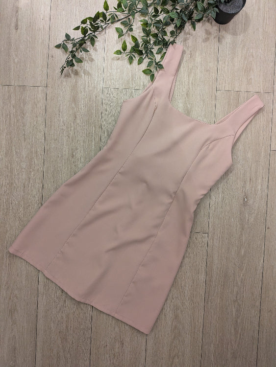 Robe rose pale décolleté en V dans le dos sublimé par un noeud blanc. 