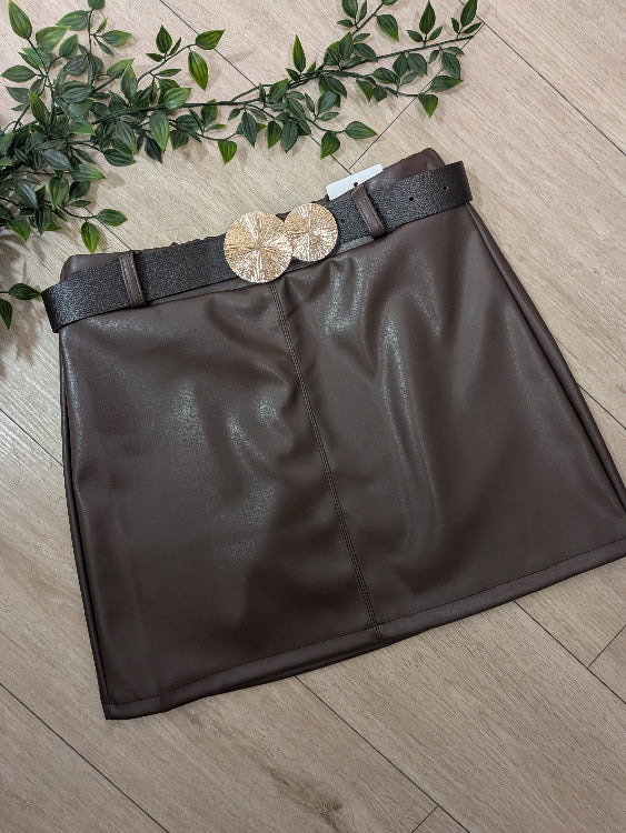 Jupe en simili cuir agrémenté d'une ceinture a boucle bijoutée doré. colorie marron. 