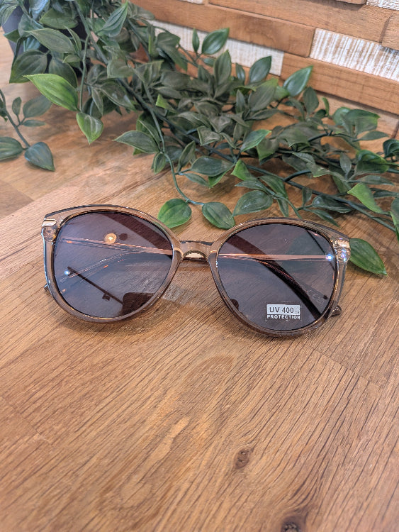 Lunettes de soleil ronde légèrement papillon. colorie beige foncé 
