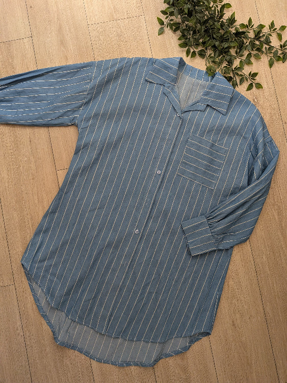 Chemise longue bleu ciel a rayures blanches. Photo a plat. 