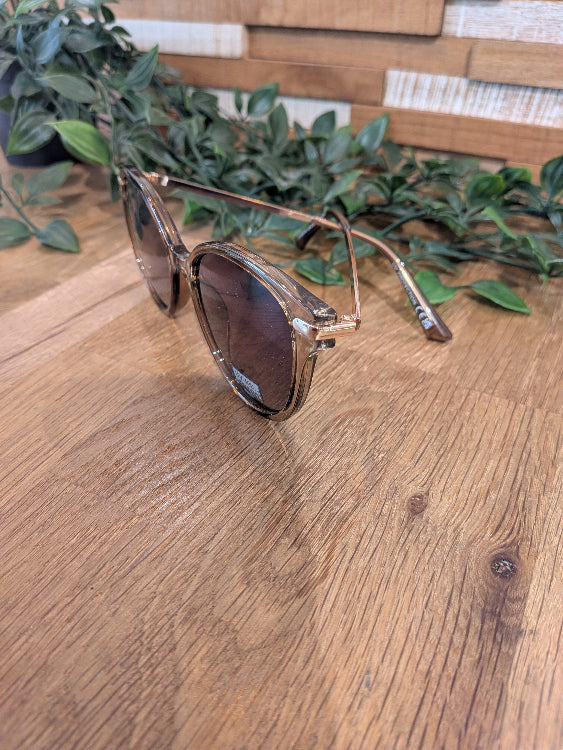Lunettes de soleil ronde légèrement papillon. colorie beige foncé. 