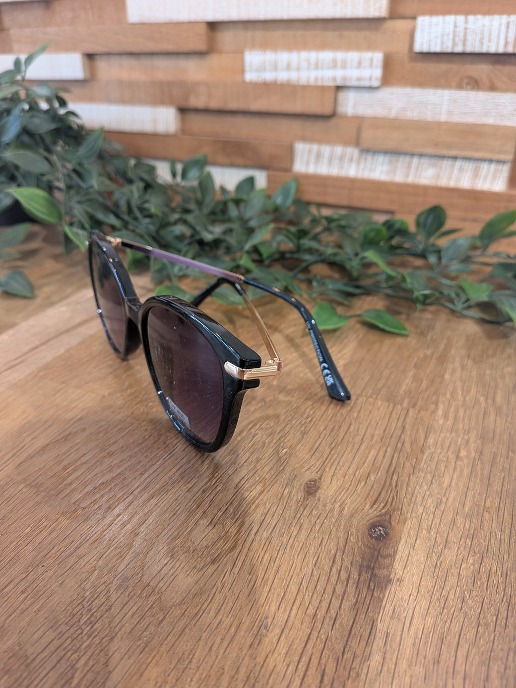 Lunettes de soleil ronde légèrement papillon. colorie noir. 