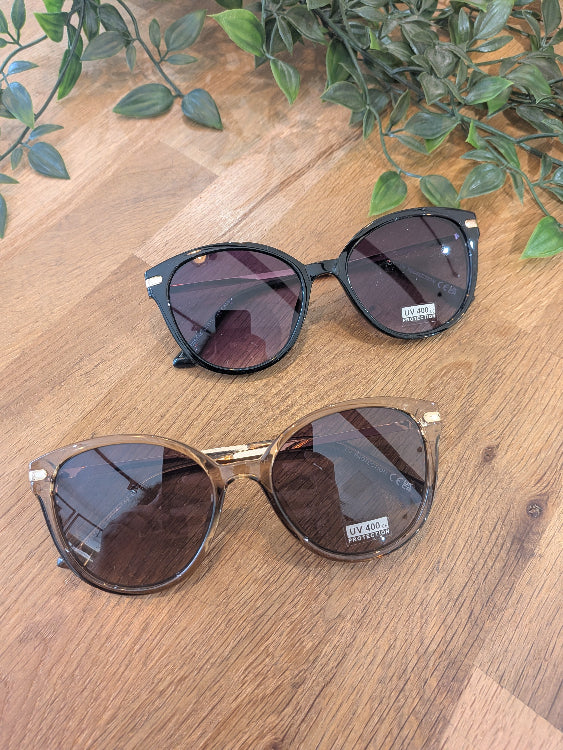 Lunettes de soleil ronde légèrement papillon. colorie beige foncé et noir. 