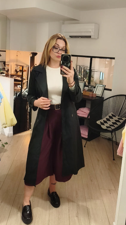 Trench fluide colorie noir porté avec un bermuda bordeau
