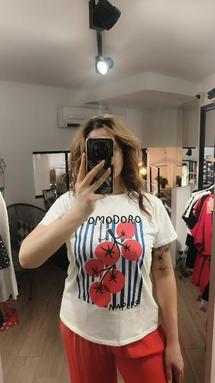 T-shirt imprimé d'une grappe de tomate sur un fond de rayures bleu foncé. Photo porté. 