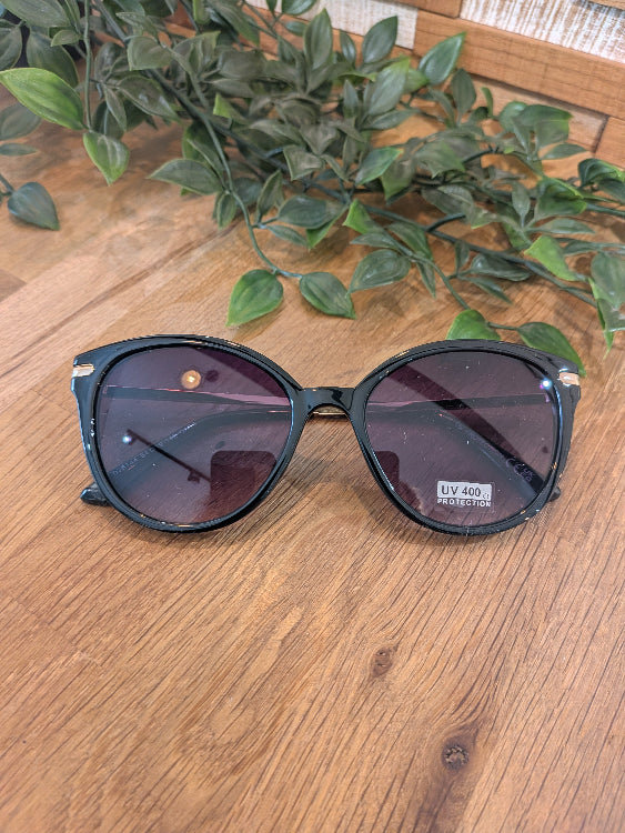 Lunettes de soleil ronde légèrement papillon. colorie noir. 