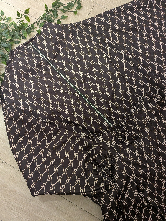 Ensemble composé d'un blouson et d'un pantalon large en tissus monogrammé marron.