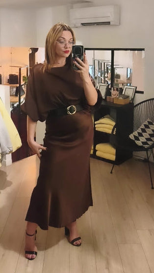 Jupe longue en satin marron porté avec une ceinture et un top en satin manche 3/4 marron. 