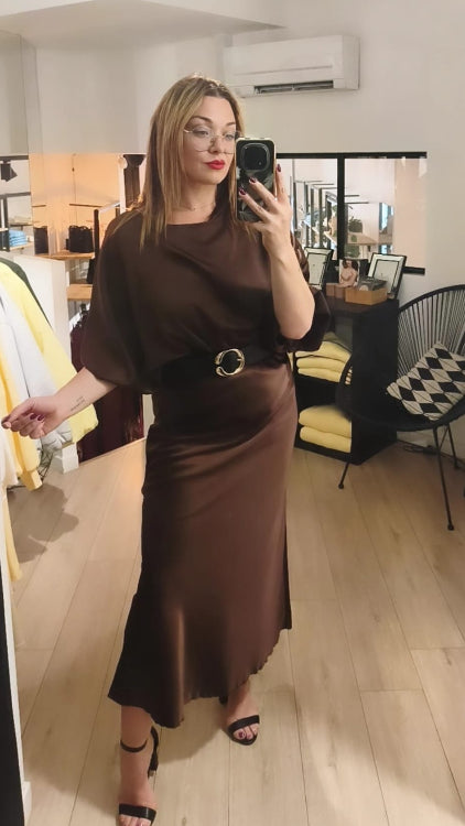 Jupe longue en satin marron porté avec une ceinture et un top en satin manche 3/4 marron. 