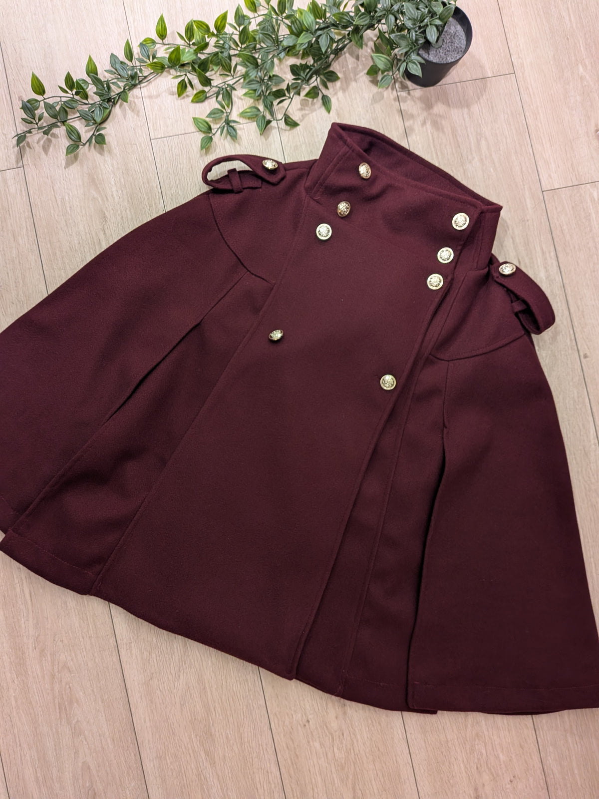 Manteau cape colorie Bordeaux . photo a plat.