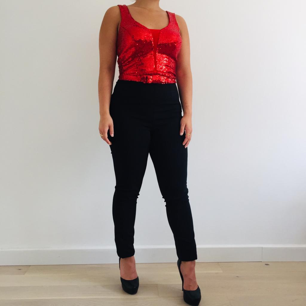 Photo de la combinaison haut paillette rouge porté avec des escarpins compensées.