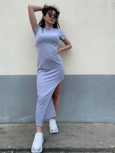 Photo porté de la robe T-shirt asymetrique grise porté avec une paire de lunette de soleil et des baskets.