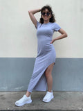 Photo porté de la robe T-shirt asymetrique grise porté avec une paire de lunette de soleil et des baskets.