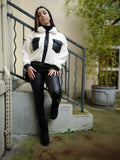 Veste bi matière blanche et noir porté avec un jean enduit noir, un sac en fausse fourrure et des bottines fourrées