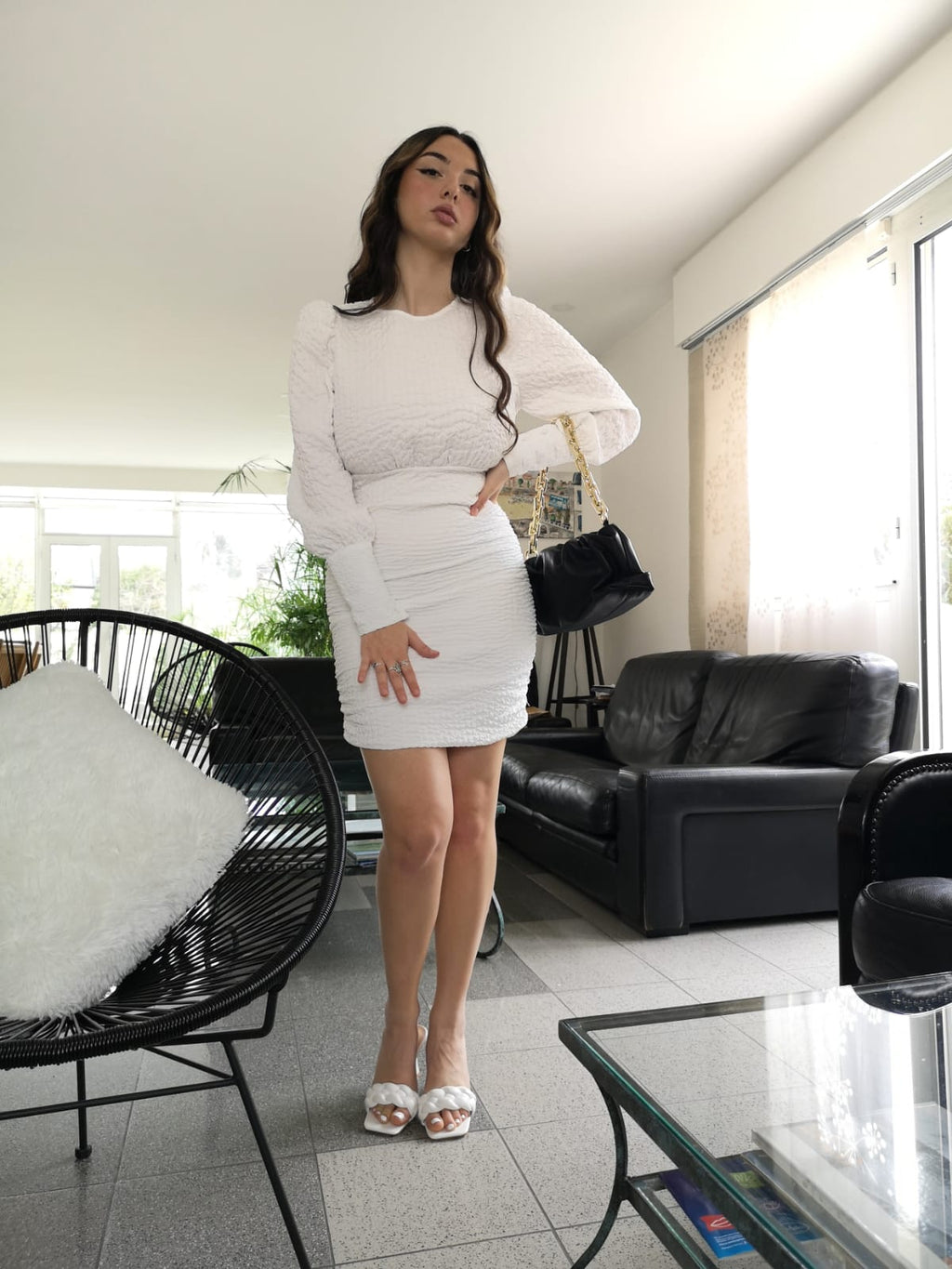 Robe en crêpe gaufré blanche porté avec des mules tressées blanches et un sac froncé