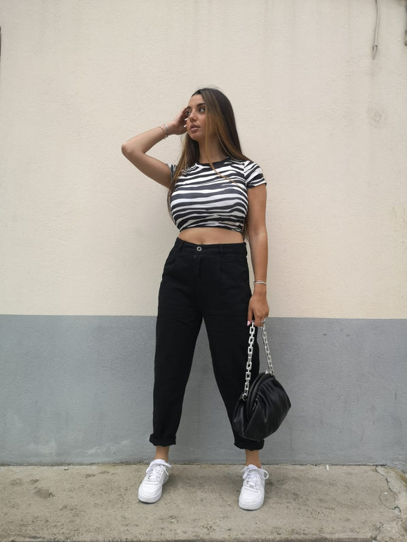 Jean noir 1526 porté avec un top imprimé zèbre et un sac porte monaie